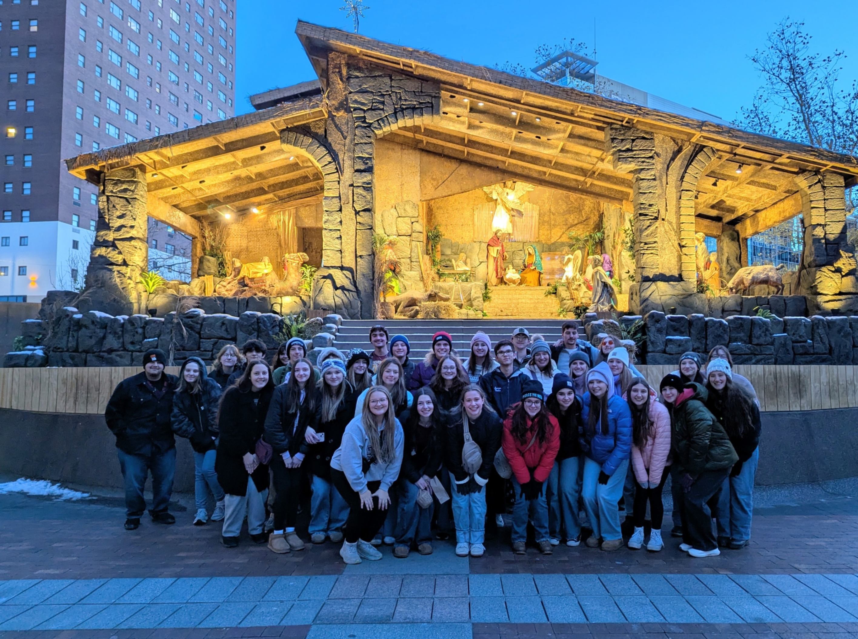 Humanities club members pose for a photo in front of the Pittsburgh creche.